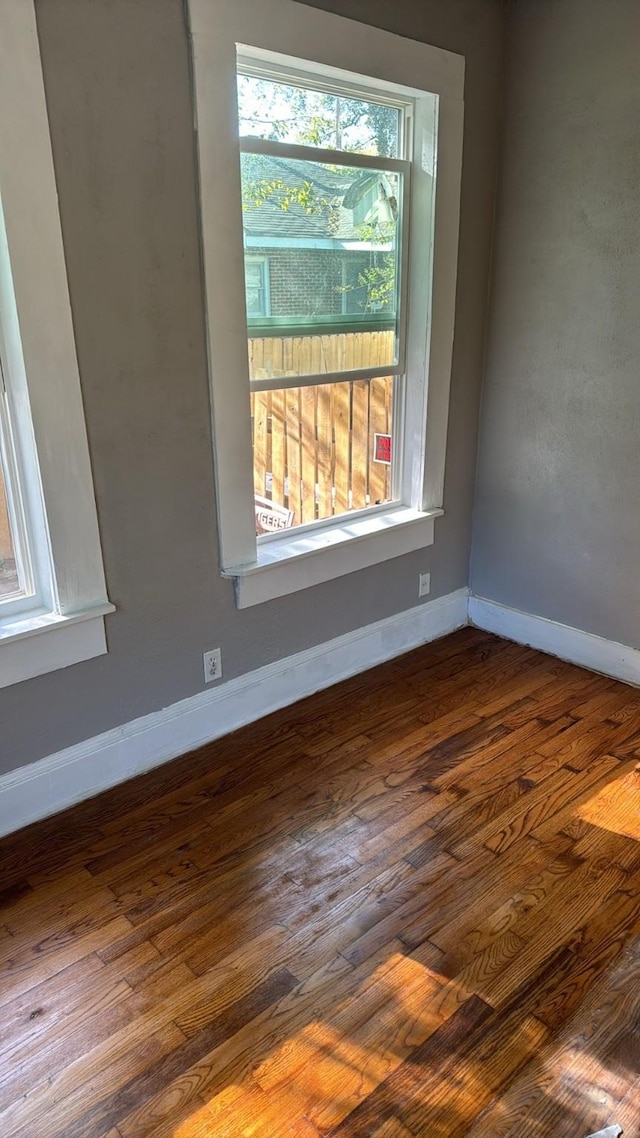 spare room with wood finished floors and baseboards