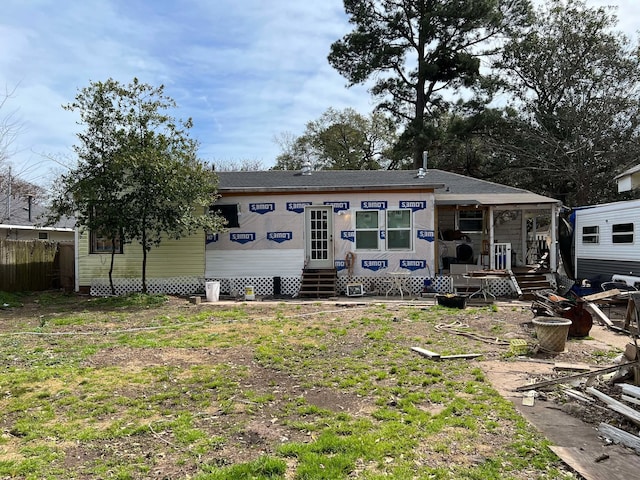 back of property featuring entry steps and fence