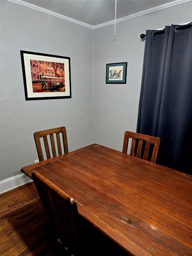 dining area with crown molding and wood finished floors