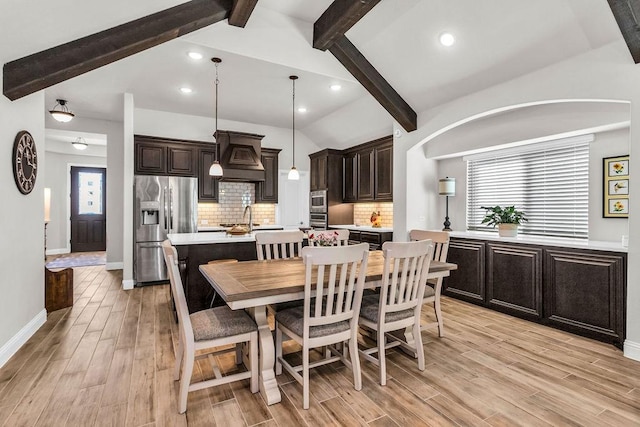 dining room featuring recessed lighting, light wood-style flooring, vaulted ceiling with beams, and baseboards