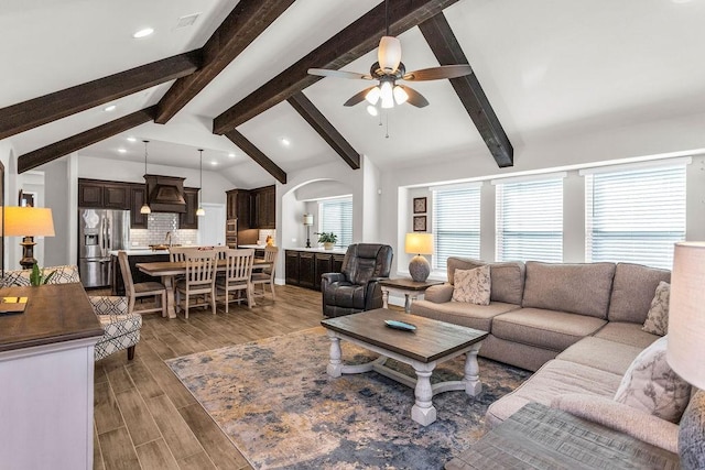 living area featuring vaulted ceiling with beams, wood finished floors, recessed lighting, and ceiling fan