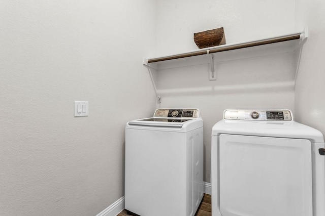 washroom featuring baseboards, laundry area, and washer and clothes dryer