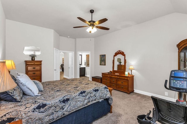 bedroom featuring a ceiling fan, baseboards, carpet floors, vaulted ceiling, and ensuite bathroom