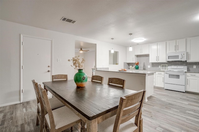 dining space with visible vents and light wood finished floors