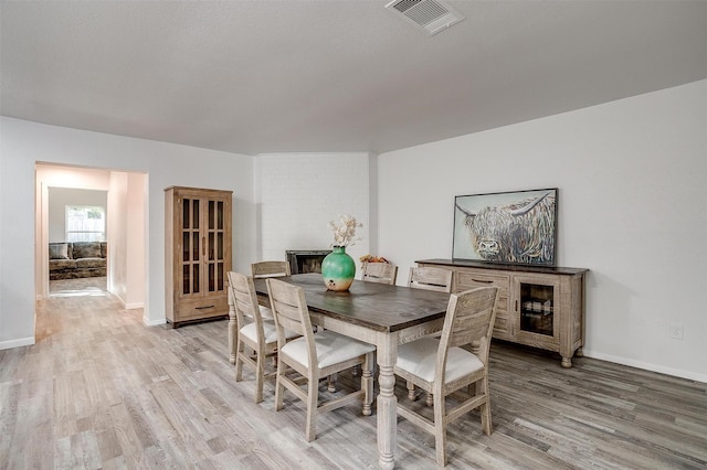 dining room with light wood-style floors, baseboards, and visible vents