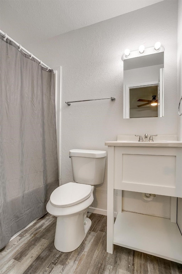 bathroom with a shower with curtain, toilet, and wood finished floors