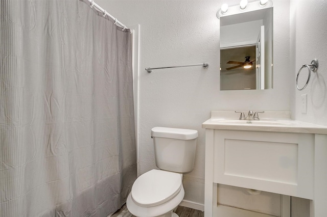 bathroom with toilet, a shower with curtain, a textured wall, and vanity