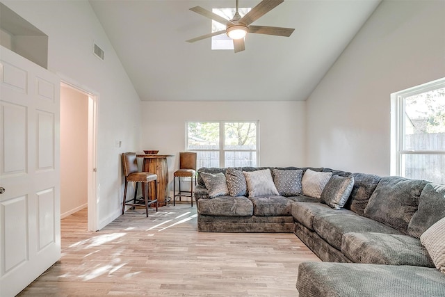 living area featuring a ceiling fan, light wood-type flooring, a healthy amount of sunlight, and visible vents