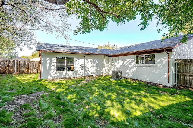 rear view of house with a yard and fence