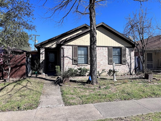 view of front of home with brick siding and fence