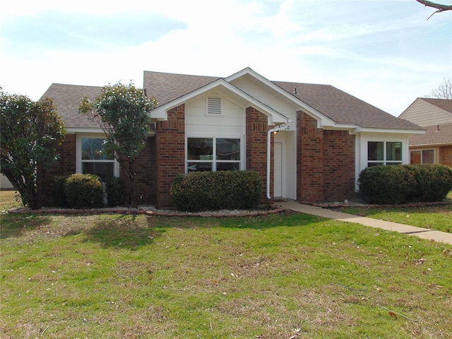 single story home with roof with shingles, a front lawn, and brick siding