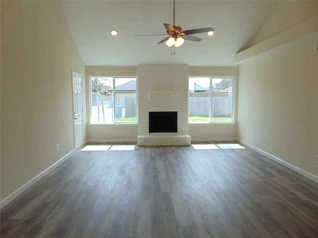 unfurnished living room featuring baseboards, dark wood-style flooring, and a healthy amount of sunlight