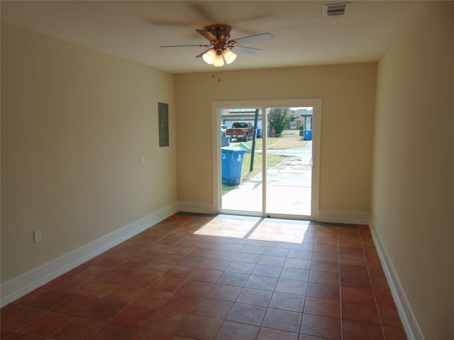 empty room featuring electric panel, baseboards, visible vents, ceiling fan, and tile patterned floors