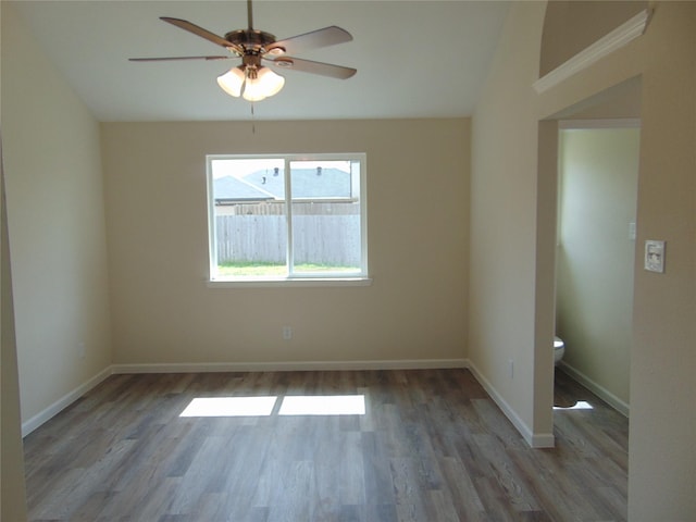 unfurnished room featuring lofted ceiling, ceiling fan, baseboards, and wood finished floors