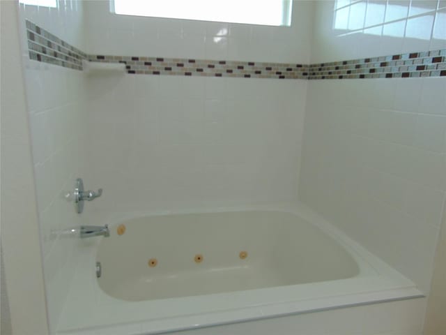 bathroom with a combined bath / shower with jetted tub