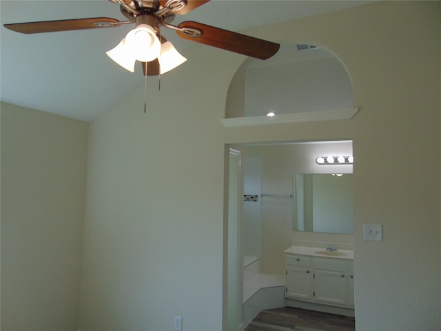 interior space featuring dark wood finished floors, visible vents, a ceiling fan, vaulted ceiling, and a sink