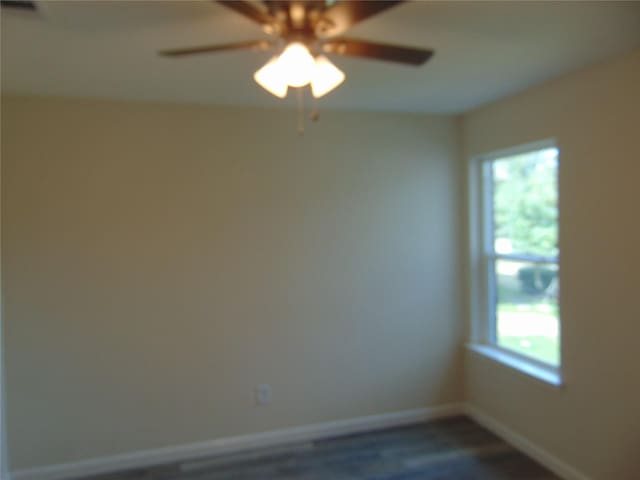 empty room with a ceiling fan and baseboards