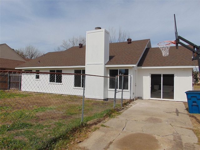 back of property featuring a chimney, fence, a lawn, and roof with shingles