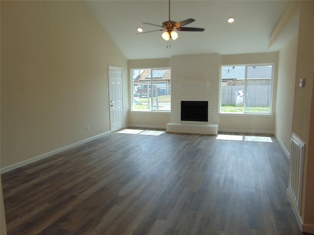 unfurnished living room with dark wood-type flooring, a fireplace, plenty of natural light, and baseboards