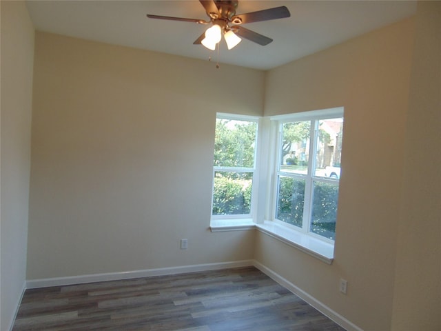 unfurnished room with plenty of natural light, baseboards, and wood finished floors