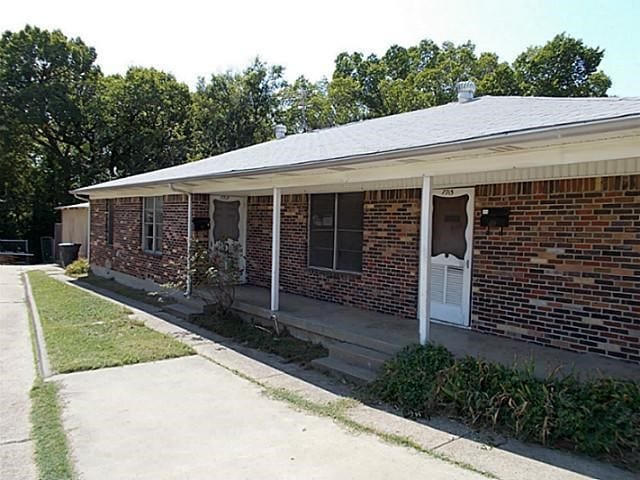 view of front of home with a porch and brick siding