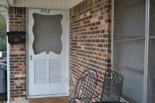 view of exterior entry featuring brick siding