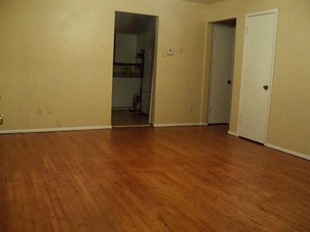 empty room featuring wood finished floors and baseboards