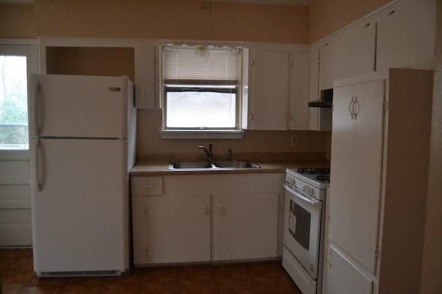 kitchen featuring range hood, white appliances, a healthy amount of sunlight, and a sink