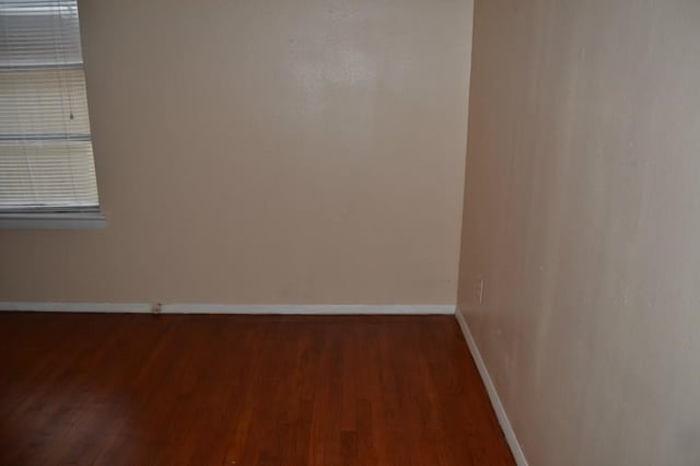 unfurnished room with wood finished floors and baseboards