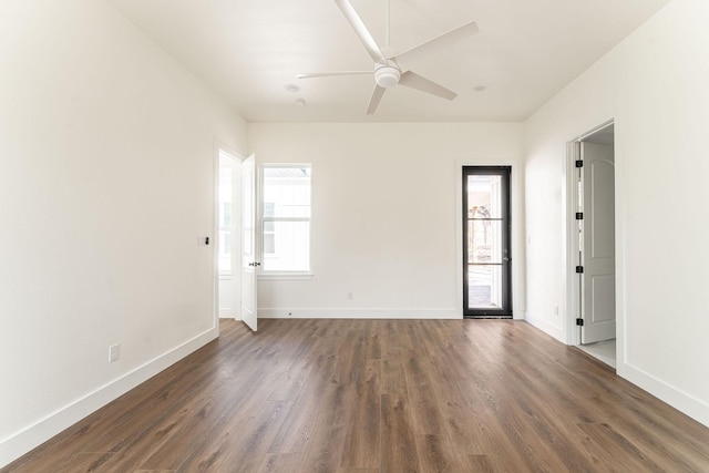 spare room featuring wood finished floors, a ceiling fan, and baseboards