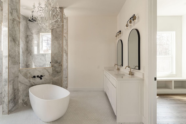 bathroom featuring a freestanding bath, double vanity, tile patterned flooring, and a sink