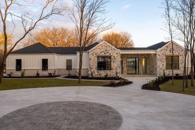 204 Deer Glade Ct, Azle, TX 76020 - view of front facade with curved driveway, board and batten siding, a front lawn, and stone siding
