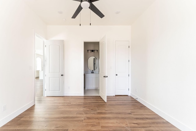 unfurnished bedroom featuring light wood-type flooring, ceiling fan, and baseboards