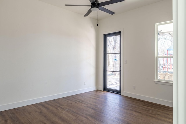 empty room with dark wood-style floors, baseboards, and a ceiling fan