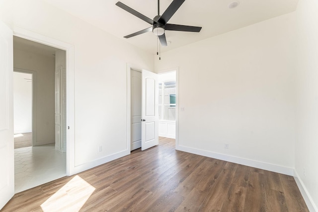 unfurnished bedroom featuring a ceiling fan, a closet, baseboards, and wood finished floors