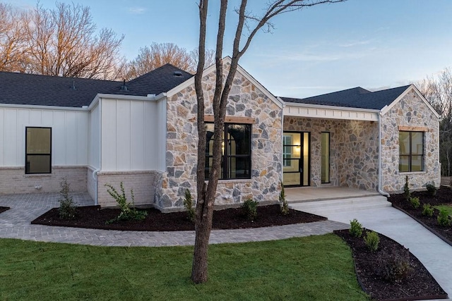 204 Deer Glade Ct, Azle, TX 76020 - view of front of home featuring a shingled roof, board and batten siding, a front yard, and stone siding