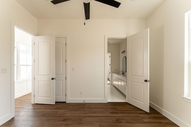 unfurnished bedroom featuring dark wood-style flooring, ceiling fan, and baseboards