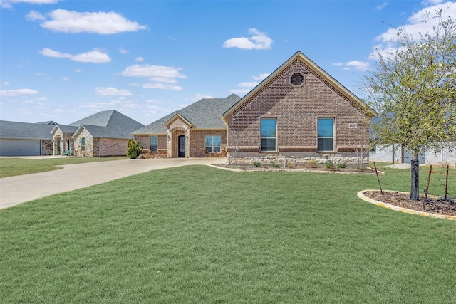 view of front facade featuring concrete driveway, brick siding, and a front lawn