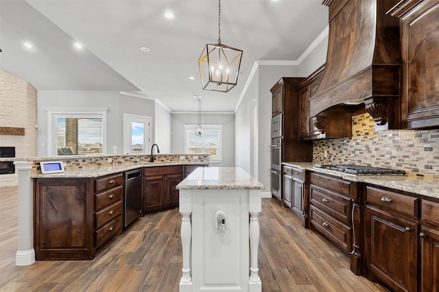 kitchen featuring dark wood-style floors, premium range hood, stainless steel appliances, and a large island with sink