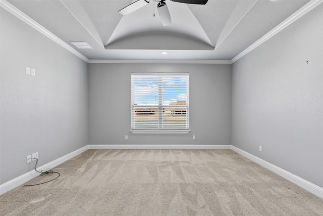 spare room featuring light carpet, a tray ceiling, crown molding, and baseboards