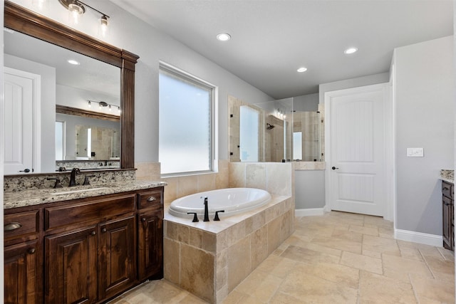 full bath featuring a stall shower, stone tile floors, vanity, a bath, and recessed lighting