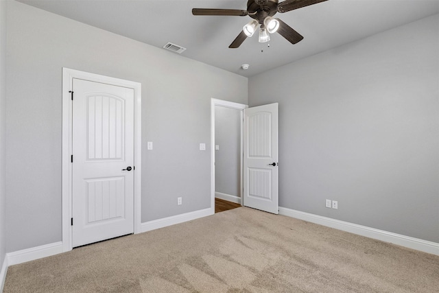 unfurnished bedroom featuring a ceiling fan, carpet, visible vents, and baseboards