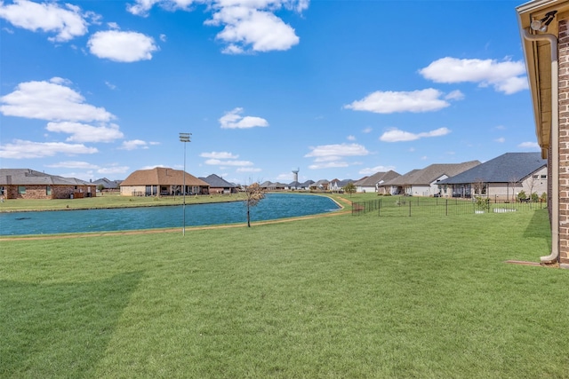 view of yard with a water view, fence, and a residential view