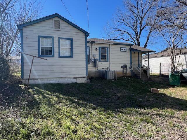 back of property with a lawn and central air condition unit