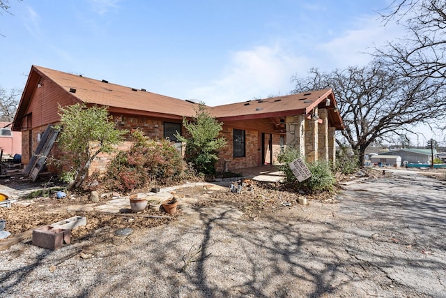 view of front of property with a patio and brick siding