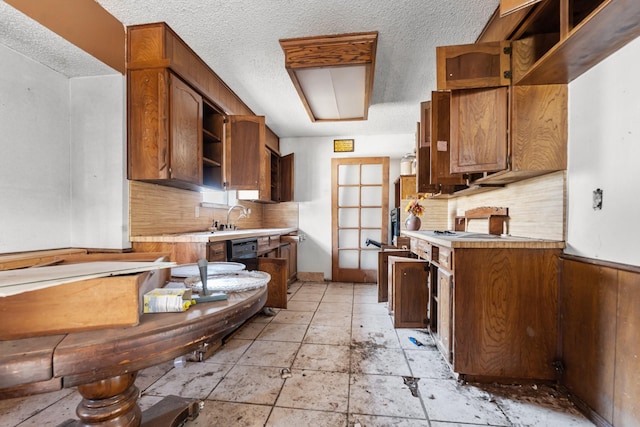 kitchen featuring brown cabinets, light countertops, a textured ceiling, open shelves, and backsplash