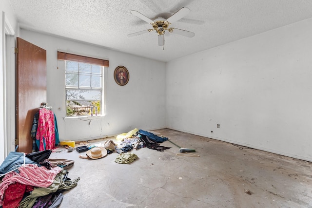 spare room with a textured ceiling, ceiling fan, and unfinished concrete flooring