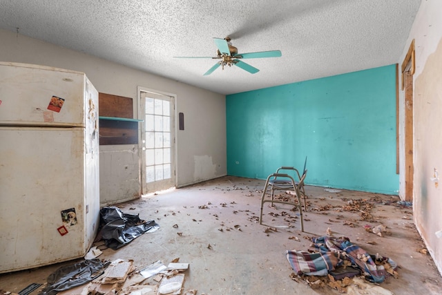 interior space with a textured ceiling and a ceiling fan