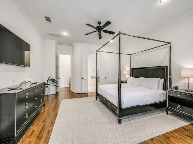 bedroom with ornamental molding, visible vents, and wood finished floors