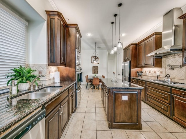 kitchen featuring wall chimney range hood, light tile patterned floors, appliances with stainless steel finishes, and a sink